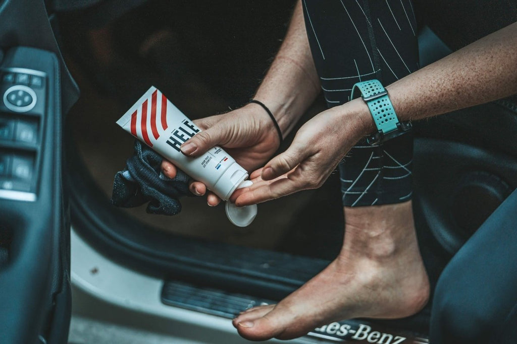 Sportive appliquant de la crème anti frottements sur son pied