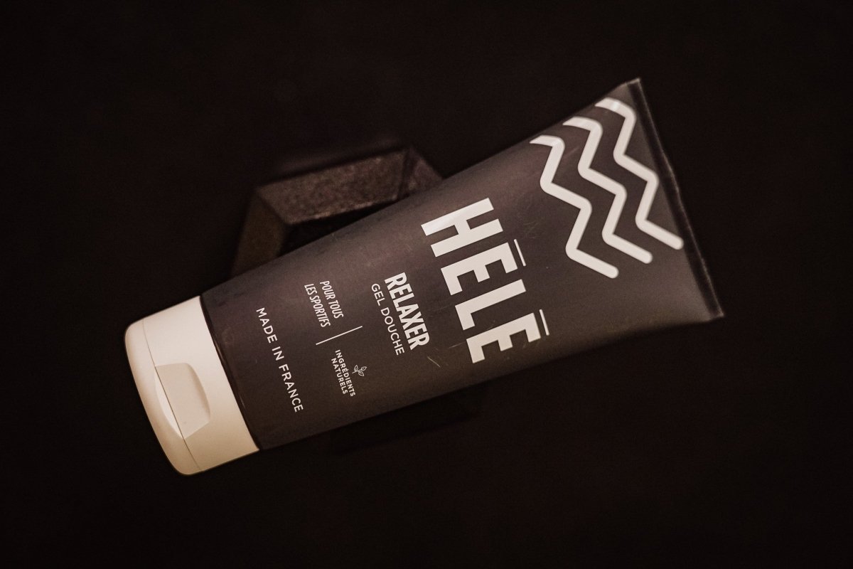 Tube de gel douche sport Relaxer sur fond noir avec haltère en arrière plan